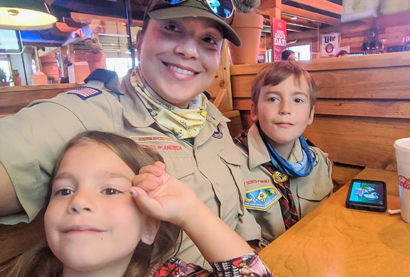 Lily Rodrigues poses in cubs scouts attire with two children