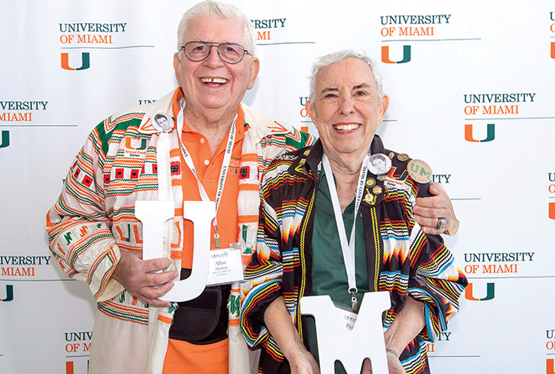 Patti and Allan Herbert pose together wearing Miami-Herbert colors